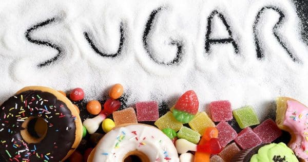 blog picture of donuts and candies with sugar spread out with the word sugar written in it